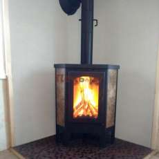 Недорогая печь-камин Бавария Эко угловая с плитой одна конфорка фото в интерьере в Слуцке