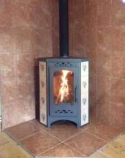 Недорогая печь-камин Бавария угловая с плитой незабудка Амазонка бай фото в интерьере в Слуцке