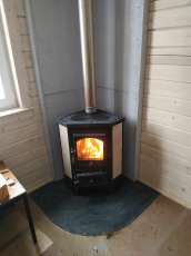 Недорогая печь-камин со стеклом Бавария угловая с плитой фото в интерьере в Слуцке